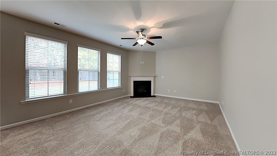 271 River Oak Street Spring Lake, NC 28390 - Photo 4 of 18 an empty room with chandelier fan and windows