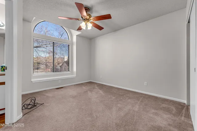 an empty room with closet and a chandelier fan