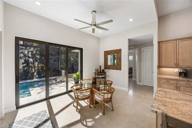 a living room with furniture a floor to ceiling window and wooden floor