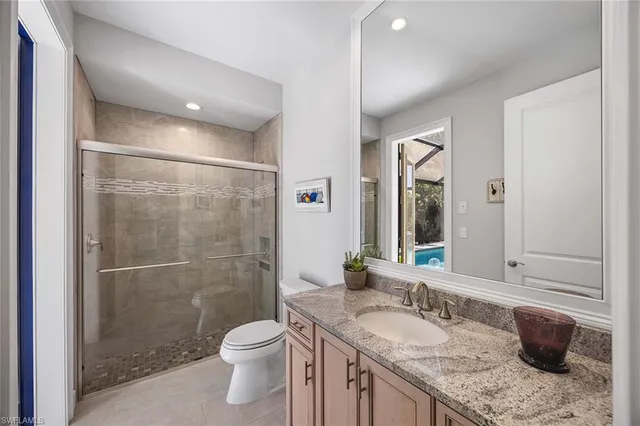 a bathroom with a granite countertop sink toilet and shower