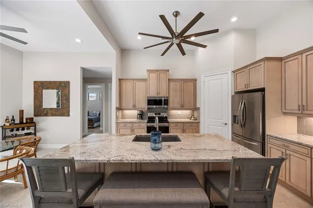 a kitchen with granite countertop a table chairs and stainless steel appliances