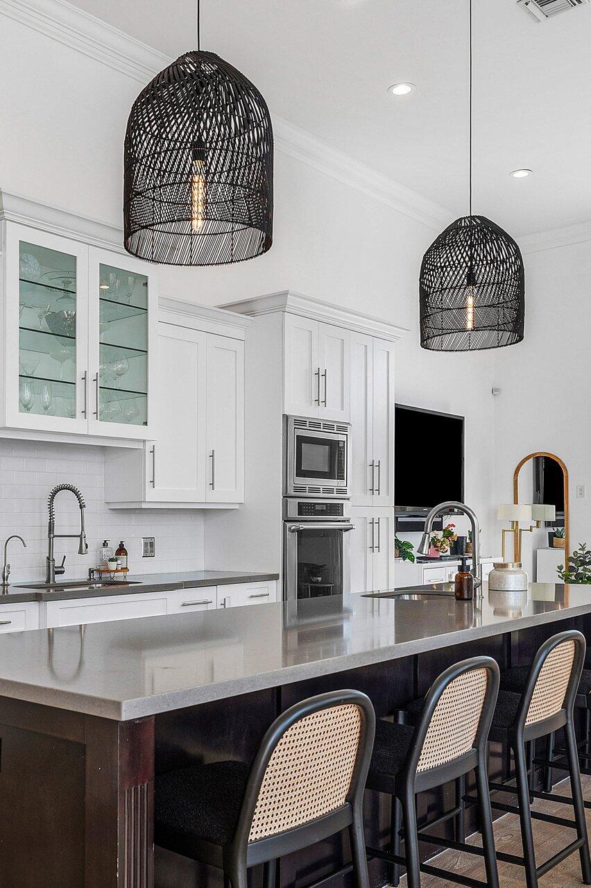 6080 Old Ocean Boulevard Ocean Ridge, FL 33435 - Photo 14 of 50 a kitchen with stainless steel appliances granite countertop a sink a microwave a refrigerator and chairs