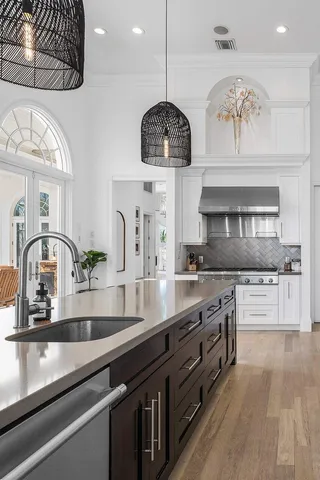 an open kitchen with granite countertop a stove and a sink