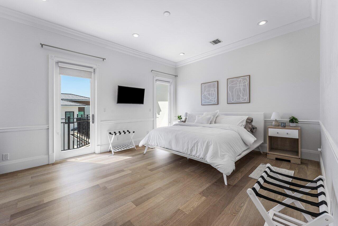 6080 Old Ocean Boulevard Ocean Ridge, FL 33435 - Photo 41 of 50 a spacious bedroom with a bed and a flat screen tv