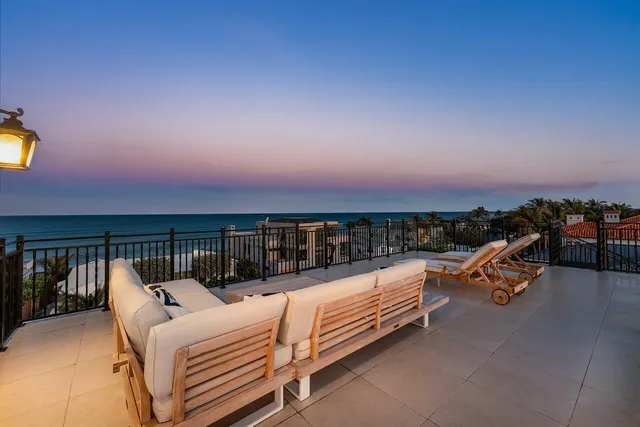 a view of a roof deck with couches and sky view