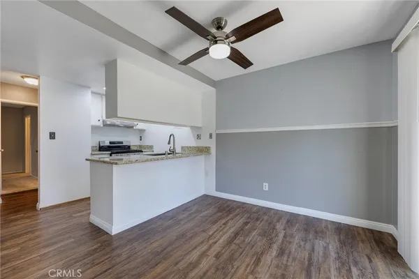 a kitchen with a dining table chairs refrigerator and microwave