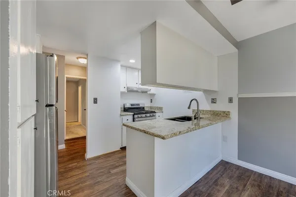 a kitchen with granite countertop white cabinets and appliances