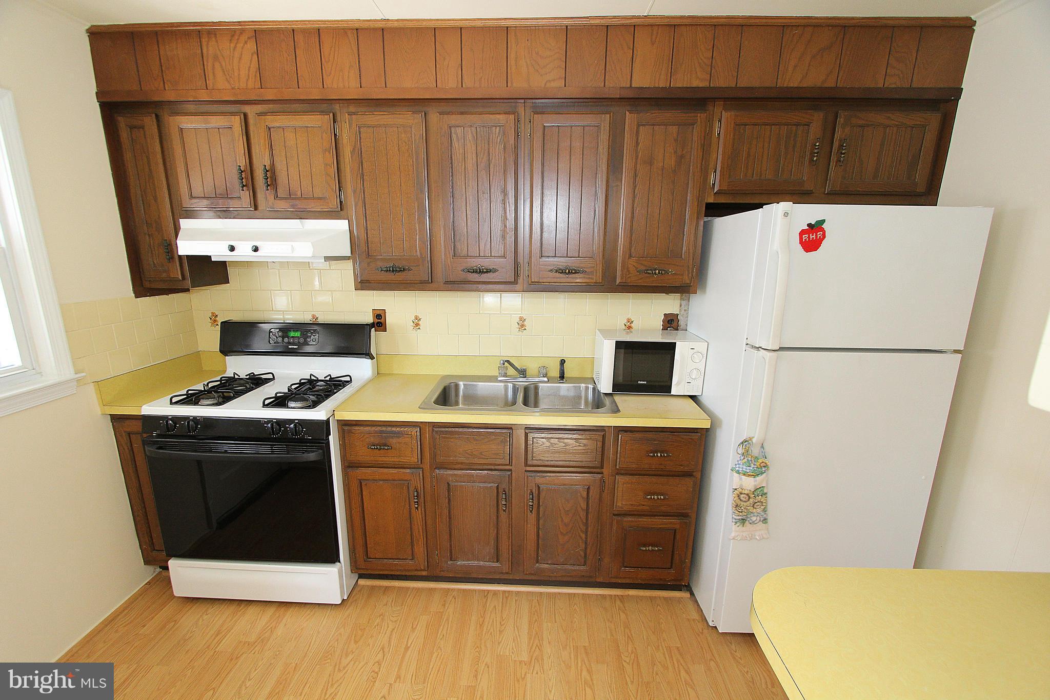 1810 Ellinwood Road Baltimore, MD 21237 - Photo 14 of 30 a kitchen with a sink a stove and a refrigerator