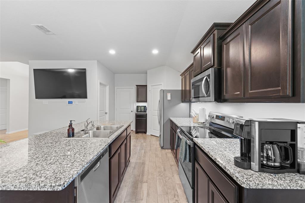 9020 Ridgeriver Way Fort Worth, TX 76131 - Photo 10 of 26 a kitchen with stainless steel appliances granite countertop a sink stove and refrigerator