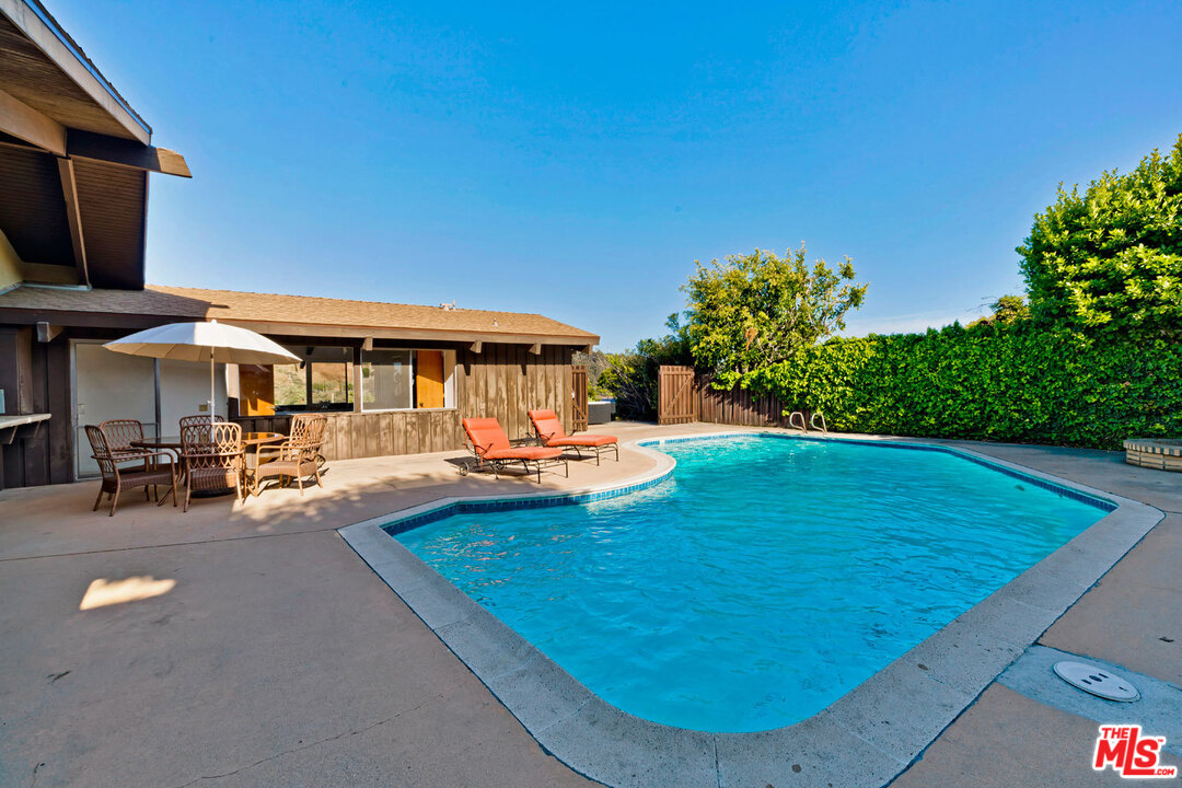 5961 Wrightcrest Drive Culver City, CA 90232 - Photo 34 of 41 a view of a swimming pool with lawn chairs under an umbrella