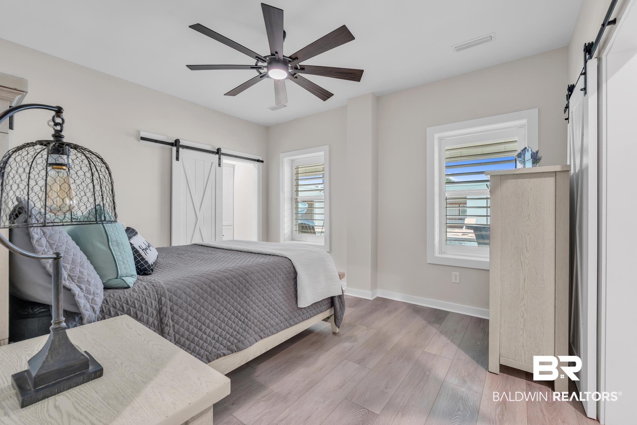 22592 Pastoral Lane Foley, AL 36535 - Photo 23 of 45 Bedroom with a barn door, light wood-style flooring, and a ceiling fan