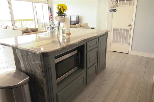 a dining hall with stainless steel appliances granite countertop a stove and a refrigerator