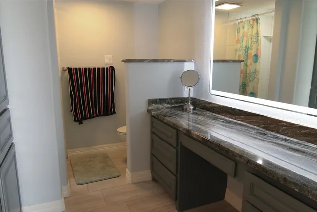 a bathroom with a granite countertop sink a mirror and a bathtub