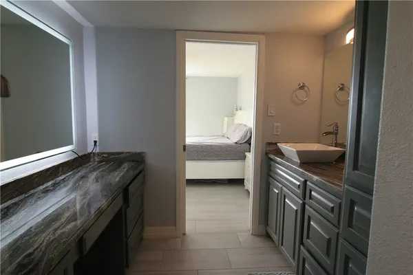 a bathroom with a granite countertop sink a mirror and shower