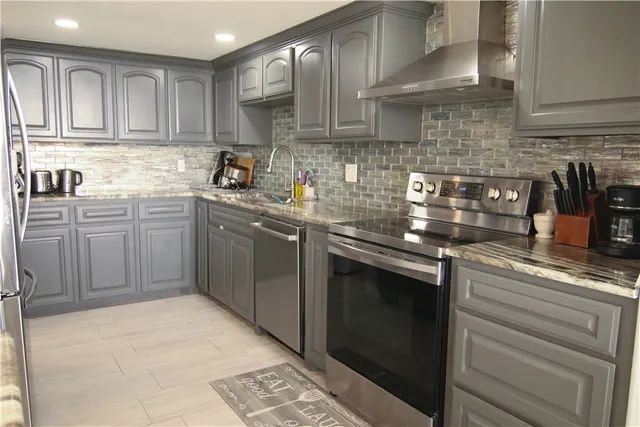 a kitchen with stainless steel appliances granite countertop a refrigerator a sink and a stove