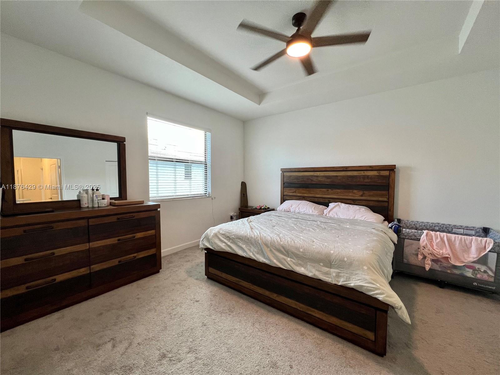 13371 Southwest 287th Street Homestead, FL 33033 - Photo 18 of 37 a bedroom with a bed and a chandelier