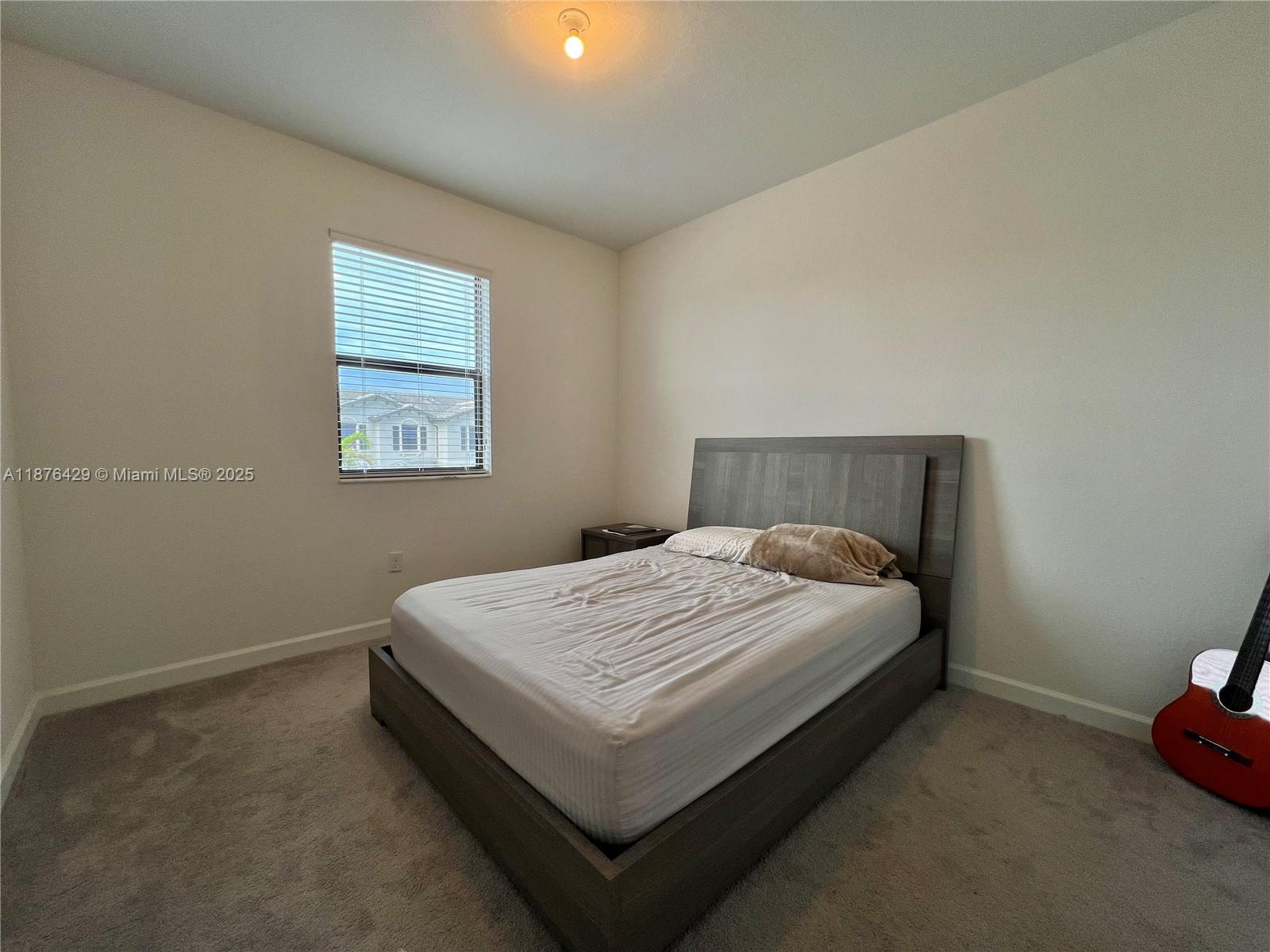 13371 Southwest 287th Street Homestead, FL 33033 - Photo 29 of 37 a bed sitting in a bedroom next to a window