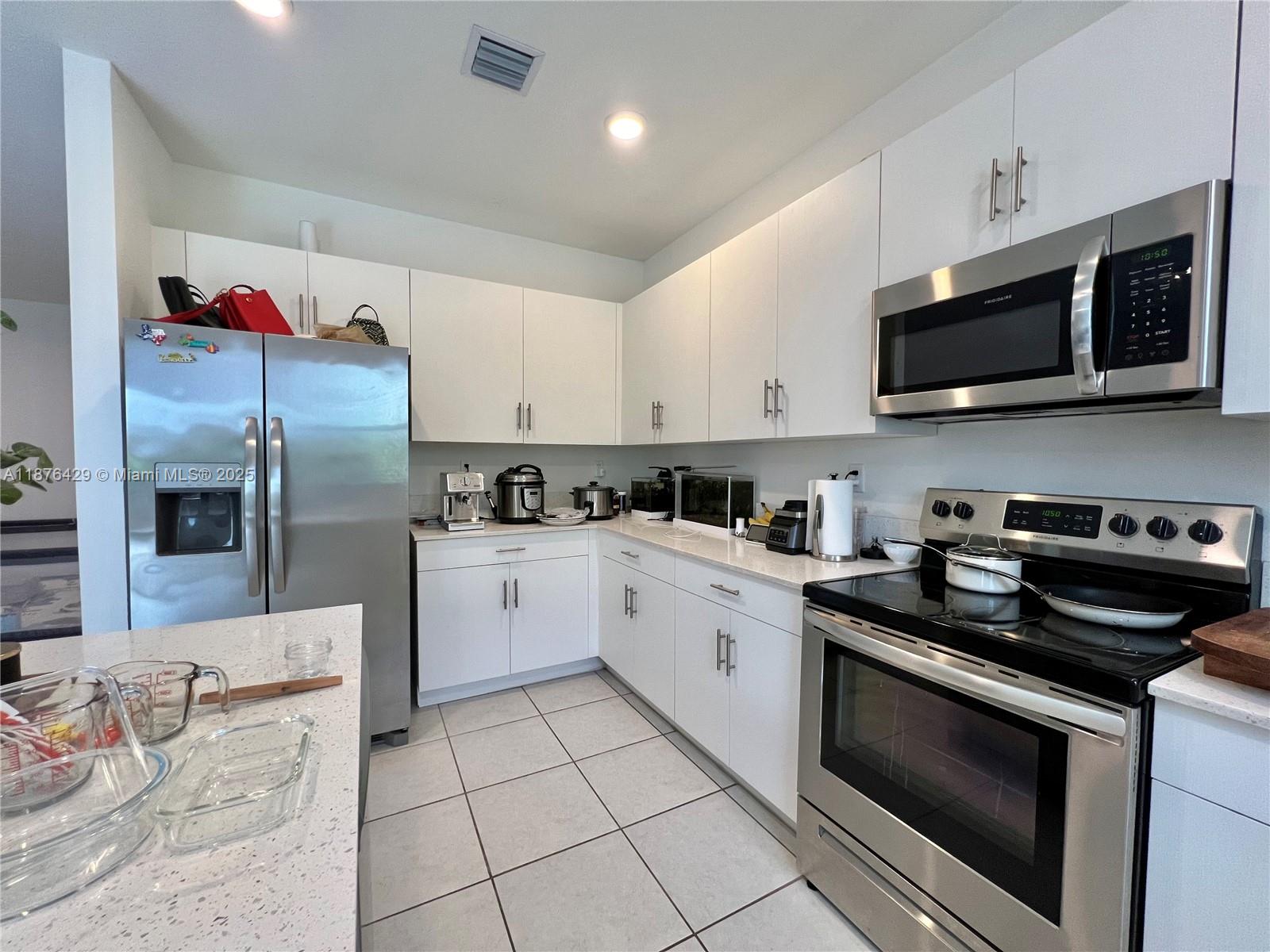 13371 Southwest 287th Street Homestead, FL 33033 - Photo 8 of 37 a kitchen with stainless steel appliances granite countertop a sink dishwasher stove top oven and cabinets