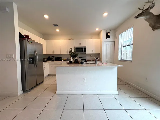 a kitchen with stainless steel appliances a refrigerator sink and microwave
