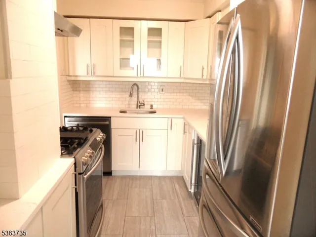 a kitchen with a sink a refrigerator and a stove