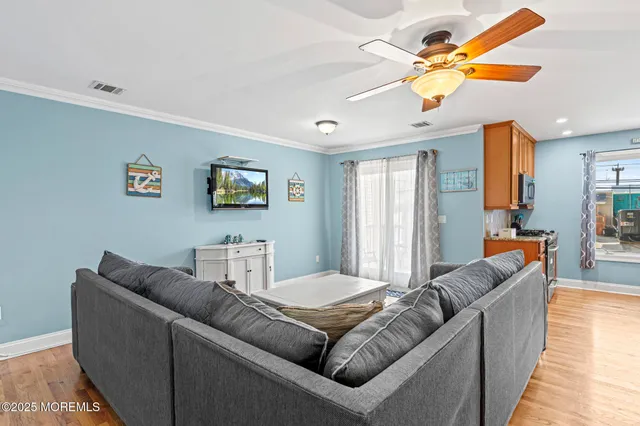 a kitchen with granite countertop a refrigerator a sink a stove and wooden floor