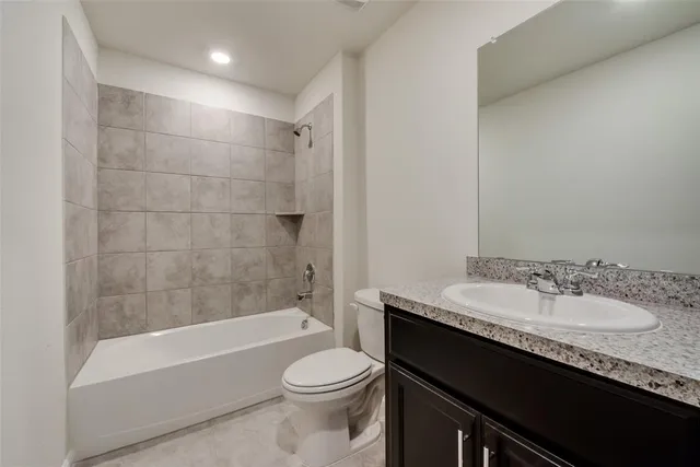 a bathroom with a granite countertop sink a toilet and bathtub