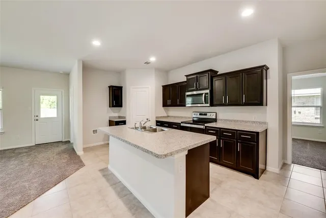 a kitchen with stainless steel appliances a stove sink microwave and cabinets