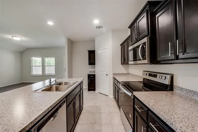 a kitchen with stainless steel appliances granite countertop counter space a sink and cabinets
