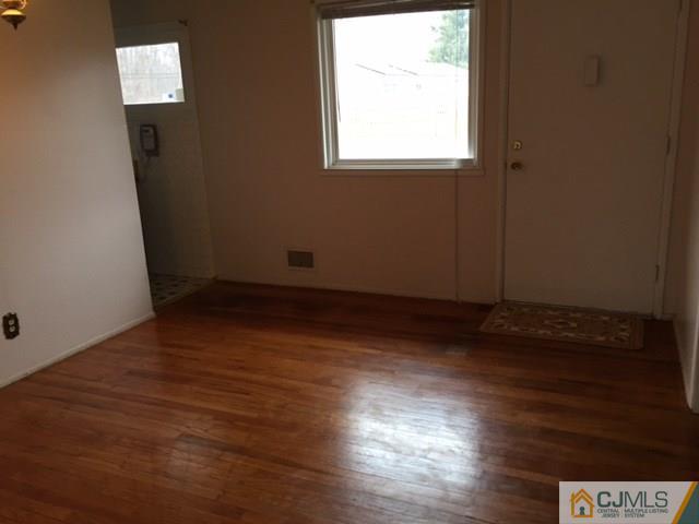 44 Clemson Road Old Bridge, NJ 08859 - Photo 3 of 12 an empty room with wooden floor and windows