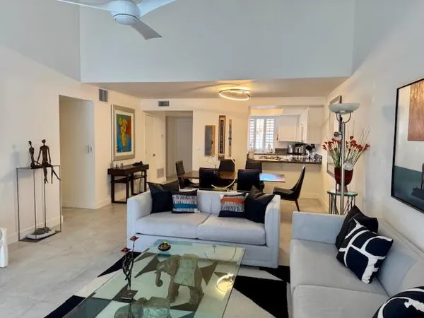 a living room with furniture large window and flat screen tv