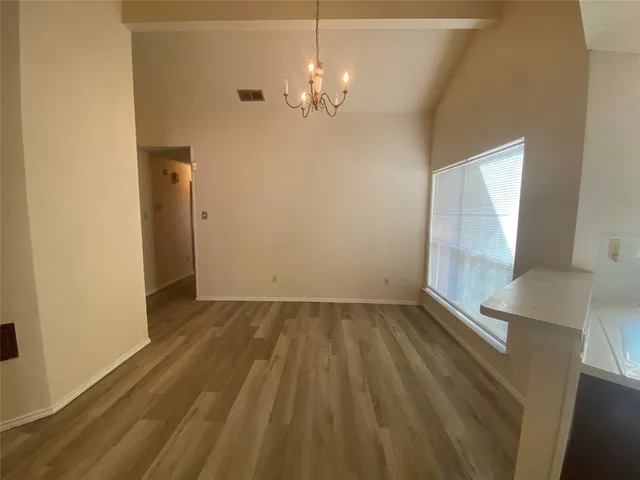 a view of a livingroom with wooden floor and a large window