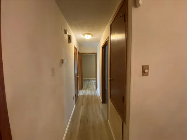 a view of hallway with stainless steel appliances wooden floor
