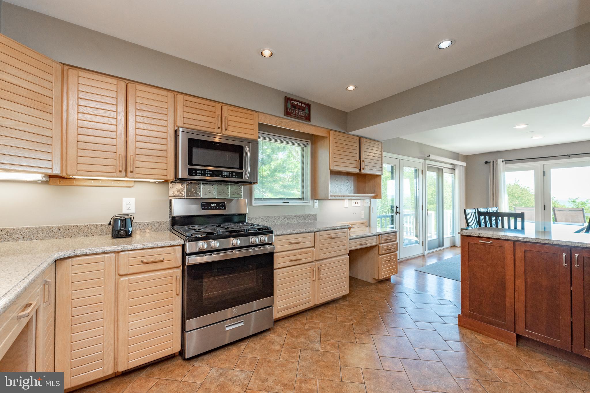 467 Paradise Ridge Road Oakland, MD 21550 - Photo 15 of 64 a large kitchen with stainless steel appliances granite countertop a stove a sink and a microwave