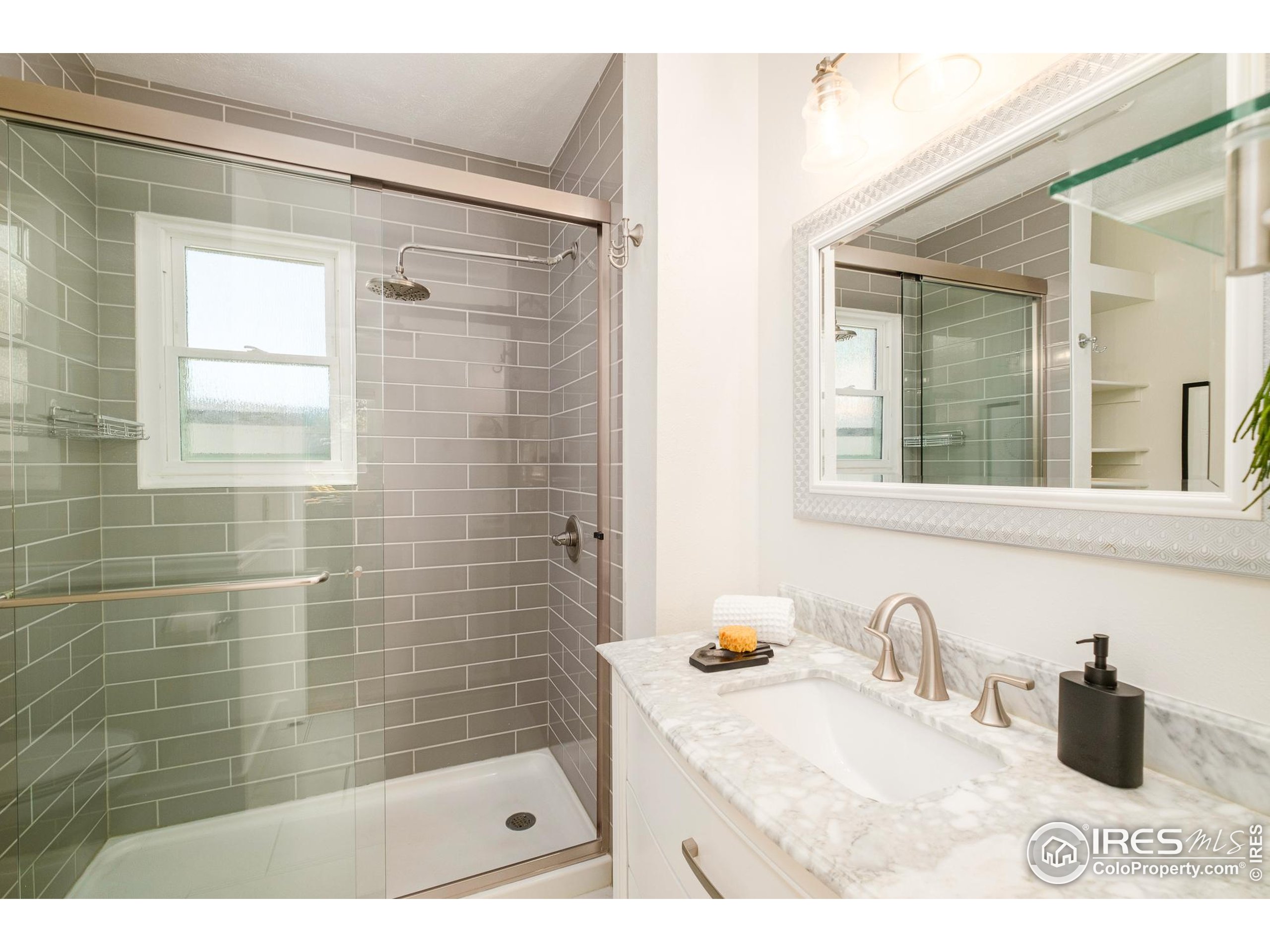 4635 Elm Court Denver, CO 80211 - Photo 16 of 30 a bathroom with a sink a shower and a mirror