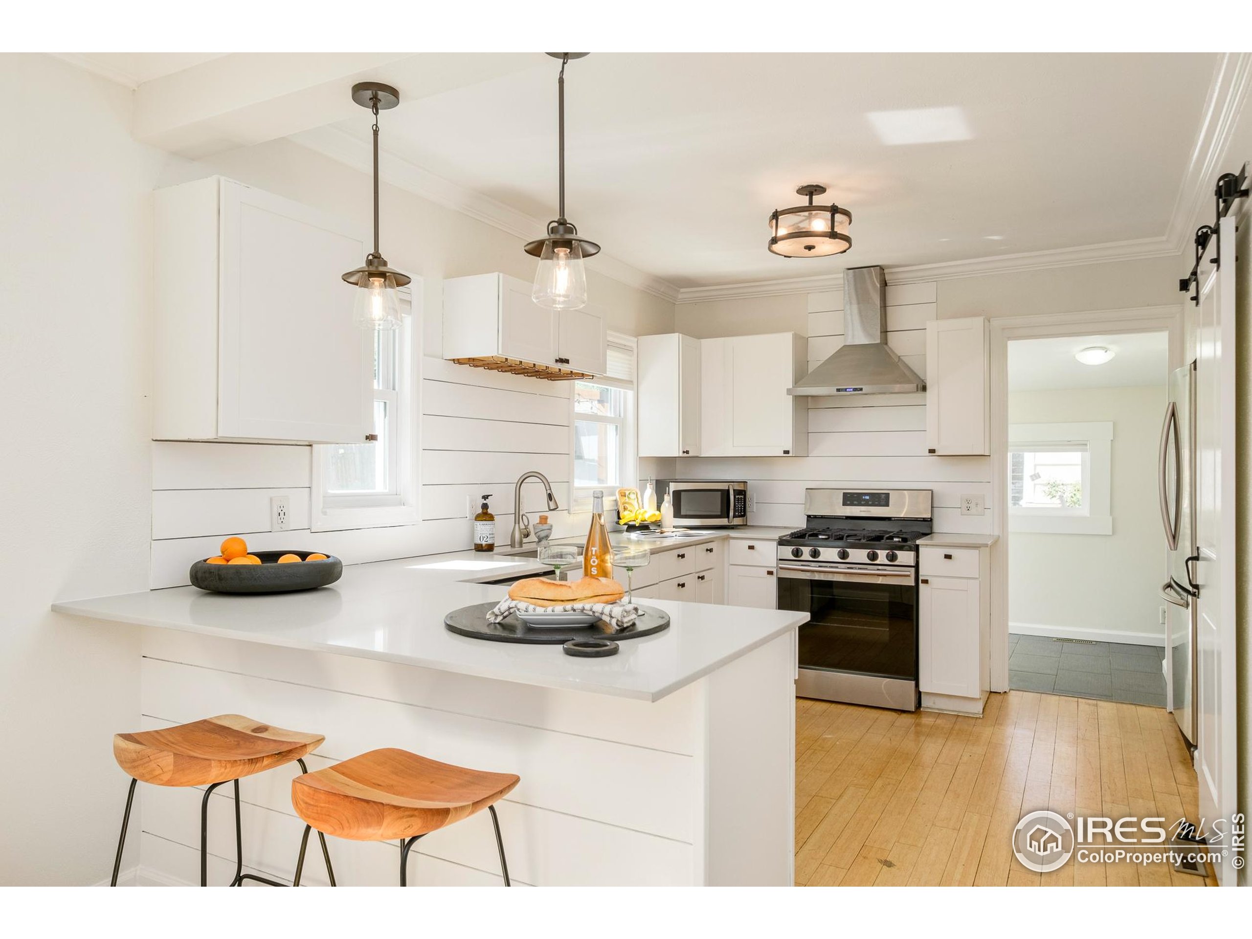 4635 Elm Court Denver, CO 80211 - Photo 8 of 30 a kitchen with refrigerator a stove and a wooden floor