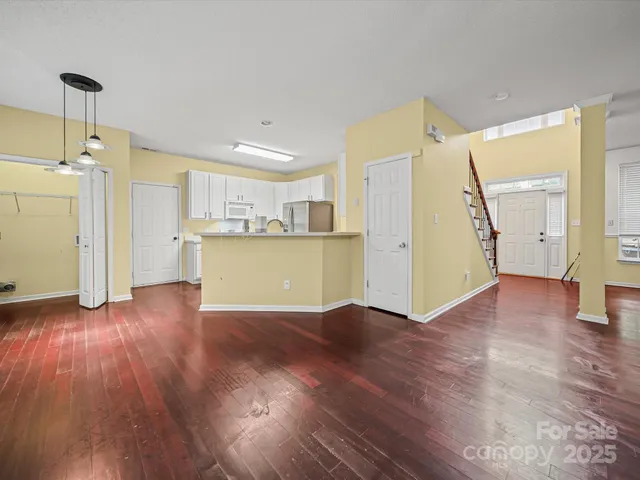 a view of a kitchen with a fridge wooden floor and a window