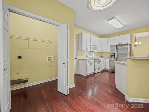 a kitchen with wooden floors and white cabinets