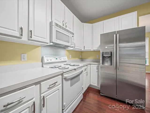 a kitchen with stainless steel appliances granite countertop a refrigerator and a stove