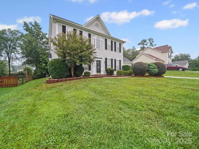 a front view of a house with a yard and trees