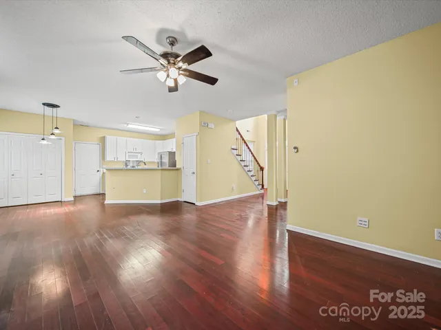 a view of a livingroom with wooden floor and a ceiling fan
