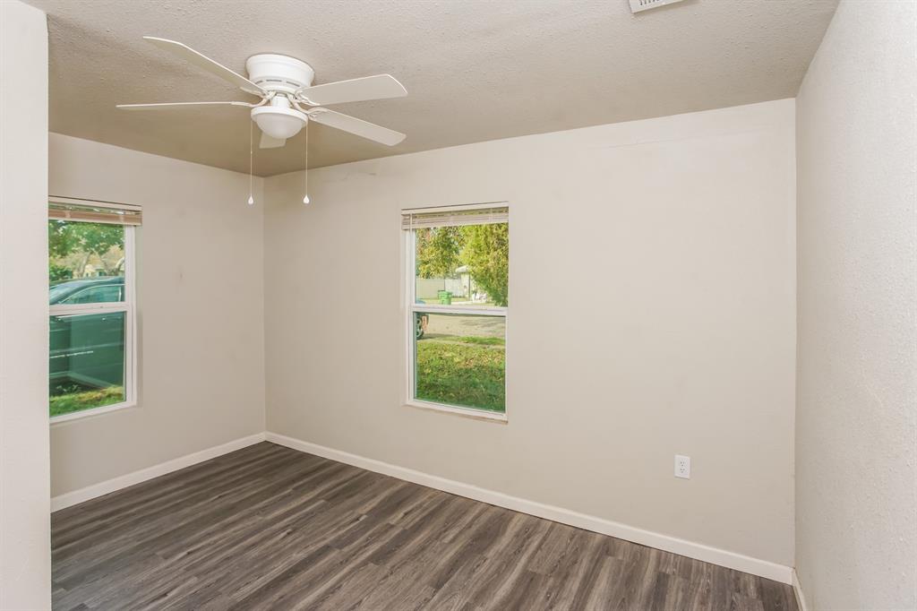 2402 Summer Avenue Waco, TX 76708 - Photo 8 of 15 Room featuring wood-finish flooring, two windows with blinds, a white ceiling fan with integrated lighting, and neutral-toned walls