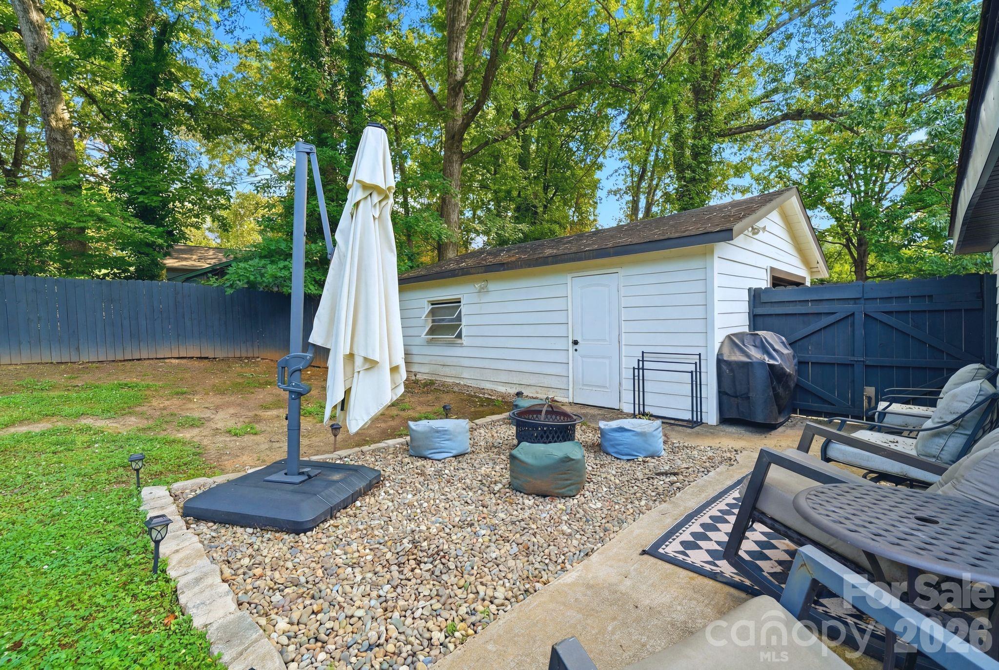 7552 Idlewild Road Charlotte, NC 28212 - Photo 37 of 40 a view of a backyard with table and chairs potted plants and wooden fence