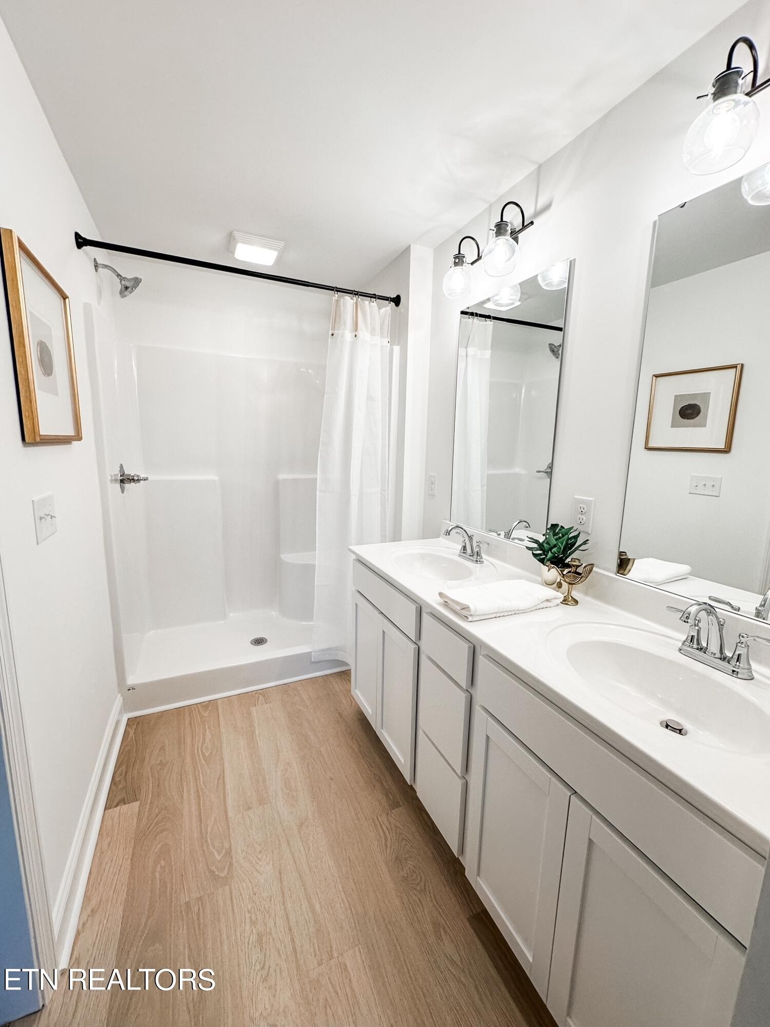 8405 Whisper Lane Powell, TN 37849 - Photo 19 of 39 a bathroom with a double vanity sink a mirror a shower and a bathtub