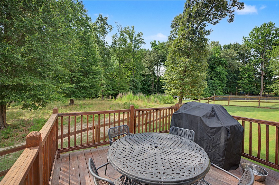 842 Conneross Road Townville, SC 29689 - Photo 23 of 34 A spacious wooden deck provides ample room for outdoor dining and entertaining, overlooking a verdant landscape.