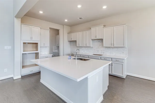 a kitchen with a sink stove and cabinets