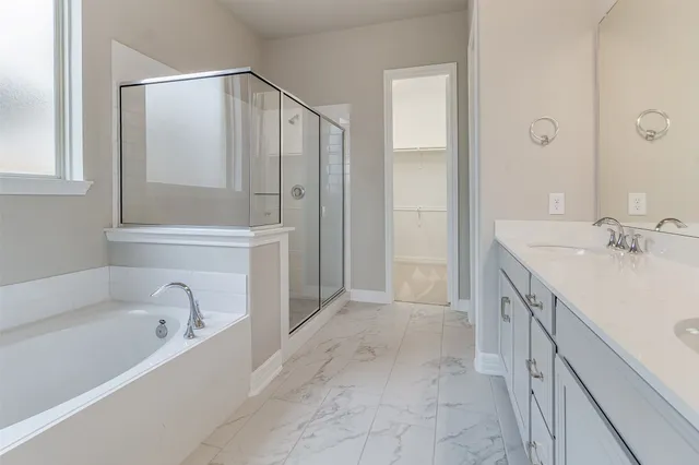 a spacious bathroom with a tub sink and mirror