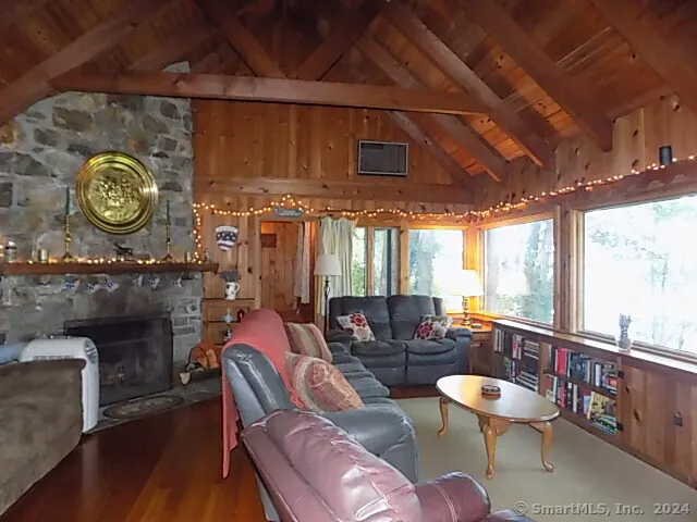a living room with furniture a flat screen tv and a floor to ceiling window