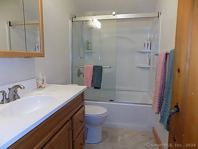 a bedroom with a bed and dresser with wooden floor