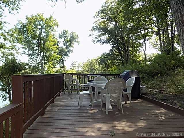 a balcony with wooden floor table and chairs
