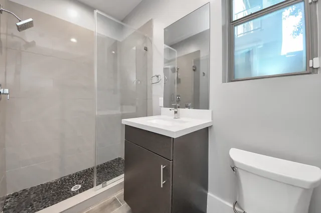 a bathroom with a sink a toilet and shower